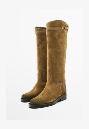 Suede knee-high boots in brown with a smooth texture, rounded toes, flat soles, and a small gold-tone buckle accent at the top.