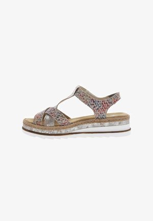 Sandales multicolores avec un motif tissé, une semelle ressemblant à du liège, des accents métalliques et un fond en caoutchouc blanc pour l'adhérence. Conception à sangle ajustable.
