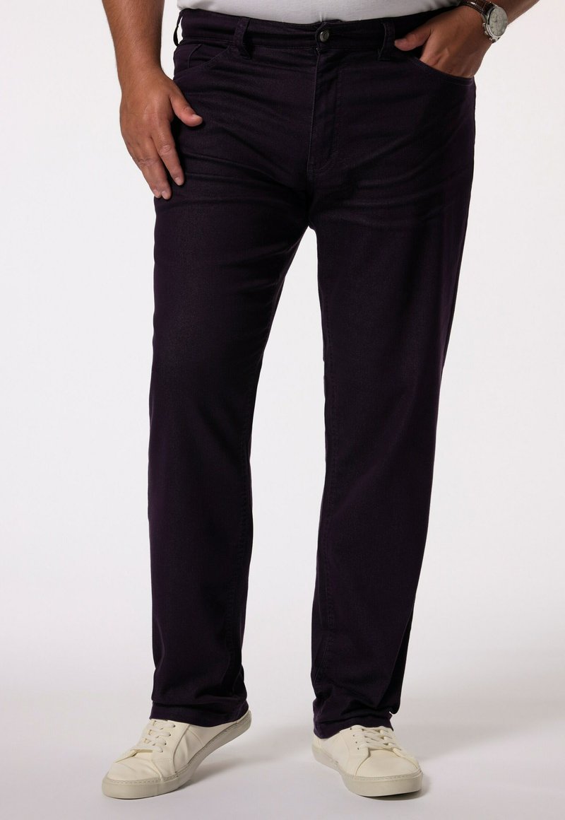 Pantalon en denim violet foncé avec une coupe droite, doté de poches avant et d'une fermeture à bouton. Associé à des baskets blanches.