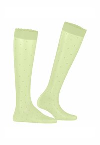 Helle grüne knielange Socken mit einer wellenförmigen Oberkante, die mit einem Punktmuster und einer glatten, strukturierten Oberfläche versehen sind.