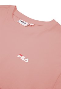 T-shirt rose FILA à col rond, avec logo FILA imprimé sur la poitrine et une étiquette de marque à l'intérieur du col.