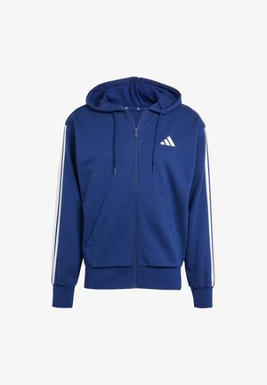 Blå lynlås hoodie lavet af blødt stof; har en kengurulomme, hvide sidelister og et logo på venstre brystområde. Justerbar hætte.