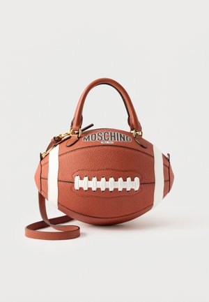 Geantă maro din piele, în formă de minge de fotbal american, cu șire albe, mânere și sigla Moschino în partea de sus.