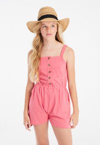 Romper de algodón rosa con escote cuadrado, cierre de botones en la parte delantera y cintura elástica. Combinado con un sombrero de paja de ala ancha con una banda negra.