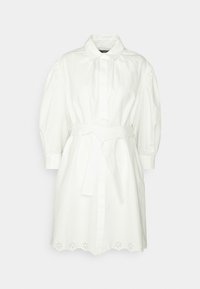 Robe blanche en coton, avec un col, des manches bouffantes, une taille ceinturée et un ourlet festonné avec des découpes florales.