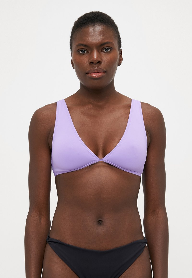 Svetlofialkový trojuholníkový bikiny top s širokými pásmi a jemnou textúrou, v kombinácii s čiernym bikiny spodkom v klasickom, minimalistickom dizajne.