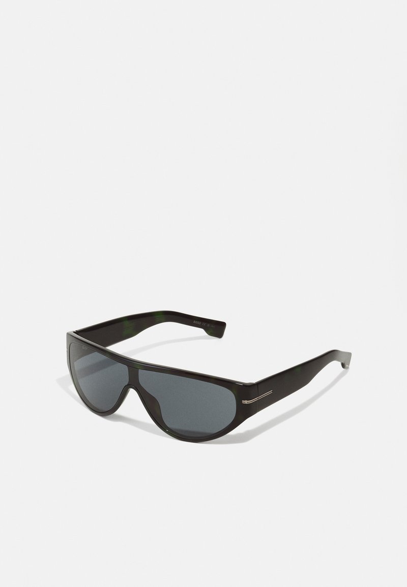 Schwarze Sonnenbrille mit großen, runden Gläsern und schlanken Kunststoffrahmen. Dunkle Gläser und dezente metallische Akzente an den Bügeln.