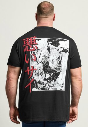 Mann trägt ein schwarzes T-Shirt mit einer Grafik eines anstürmenden Nashorns und roten japanischen Zeichen auf dem Rücken.
