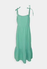 Une robe vert clair sans manches, fabriquée en tissu doux avec des bretelles ajustables à nouer et une jupe froncée à volants.