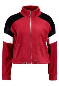 Punakarett fleece-takki, jossa on musta, valkoinen ja punainen väri-blokattua suunnittelua. Ominaisuuksiin kuuluu korkea kaulus, täysi vetoketju ja kaksi etutaskua.