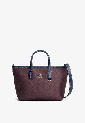 Rektangulær mørkerød og marineblå håndtaske med marineblå hanke, aftagelig skulderrem, hvid syning og et metal monogramlogo på fronten.