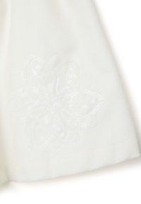 Tela blanca con un diseño floral, adornada con lentejuelas. La textura parece suave, con un sutil bordado que contornea la forma de la flor.