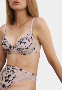 Soutien-gorge avec dentelle et culotte taille haute assortie en rose doux avec des motifs floraux sombres, dotés d'un tissu lisse et de bretelles ajustables.