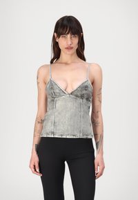 Γκρίζα τζιν καμισόλα με λεπτούς ρυθμιζόμενους ιμάντες, βαθύ V-ντεκολτέ και λεπτομέρειες από ραφές. Το ύφασμα έχει μια φθαρμένη υφή.