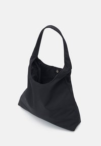 Borsa tote nera in tessuto, con forma angolata, due manici lunghi e chiusura interna a pulsante a pressione. Texture liscia, senza pattern visibili.