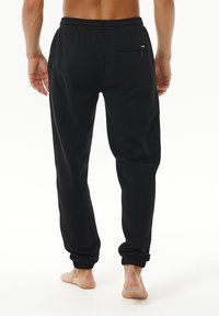 Sorte sweatpants med elastisk talje, joggermanchetter og en baglomme med lynlås, lavet af blødt, struktureret stof.