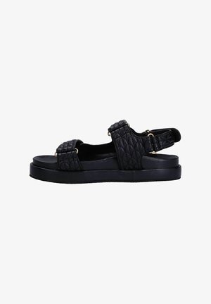 Black quilted sandals with a flat sole, featuring two adjustable straps and gold hardware accents for a secure fit.