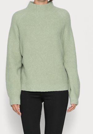 Ljusgrön stickad tröja med hög krage, ribbade ärmslut och nederkant, med en texturerad, mjuk yta och avslappnad passform.