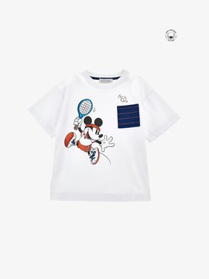 Camiseta de algodón blanca con un personaje de dibujos animados jugando al tenis, con un bolsillo a rayas azules y detalles rojos en el atuendo del personaje.