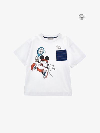 Λευκό βαμβακερό T-shirt με σχέδιο ενός κινούμενου χαρακτήρα που παίζει τένις, με μια μπλε ριγέ τσέπη και κόκκινες λεπτομέρειες στην ενδυμασία του χαρακτήρα.