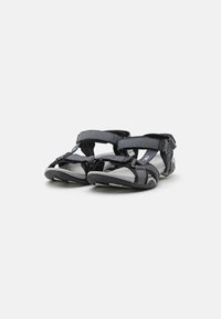 Sandales noires et grises avec des sangles ajustables, une semelle texturée et une conception robuste adaptée aux activités de plein air.