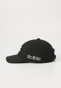 Sort baseball cap lavet af bomuld, med hvid broderet tekst på siden og en buet skygge. Justerbar rem på bagsiden.