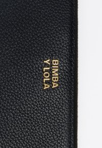 Portafoglio in pelle nera texturizzata con logo in tono oro "BIMBA Y LOLA" impresso sulla parte anteriore, dotato di chiusura con zip lungo il bordo.