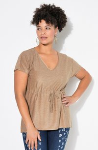 Glinsterende gouden V-hals top met korte mouwen en broek met trekkoord in de taille. Gecombineerd met donkere jeans met een luipaardprint.