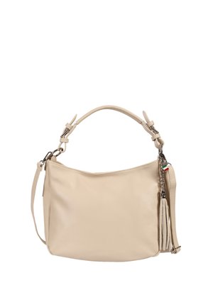 Beige leather handbag with short handle and long adjustable strap, featuring a tassel and small flag detail on metal chain.