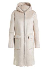 Dlouhý béžový kabát s kapucí, předním zipem, dvěma velkými klopovými kapsami a měkkou fleecovou podšívkou viditelnou uvnitř kapuce.