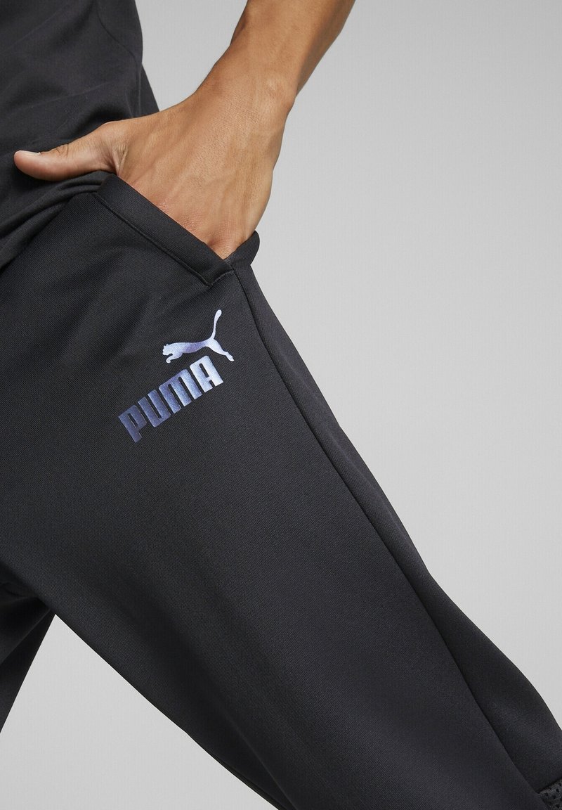 Černé sportovní kalhoty Puma s bočními kapsami, vyrobené z texturované látky a s iridescenčním logem na stehně. Hladký, přiléhavý střih.