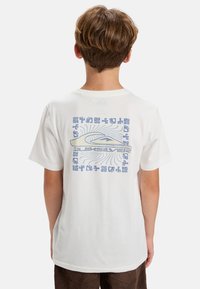 Hvit bomulls t-skjorte med et blått grafisk motiv på baksiden med abstrakte design og tekst. Korte ermer og rund halslinning.