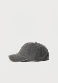Γκρι τζιν καπέλο baseball με καμπυλωτό γείσο, σχεδιασμό με έξι πάνελ και υφή επιφάνειας. Διαθέτει οπές αερισμού και ρυθμιζόμενο λουράκι.