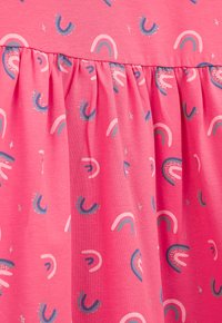 Rosa Stoff mit einem sich wiederholenden Muster aus kleinen, stilisierten Regenbögen in Weiß und Blau, mit verstreuten Funkeln. Design mit gerafft Rock.