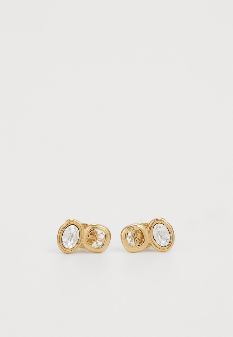 Boucles d'oreilles en ton or avec des cristaux clairs ovales, présentant des designs découpés complexes et une finition lisse et brillante.