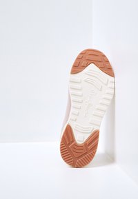 Lättviktig sneaker med en texturerad gummisula, rosa meshovandel och vita accenter. Har ett mönstrat mönster för grepp.