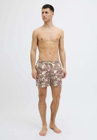 Costumi da bagno marrone con motivo floreale, dotati di una vita elasticizzata e un cordoncino, caratterizzati da una vestibilità rilassata e un tessuto leggero e testurizzato.