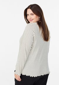 Leichter, cremfarbener Pullover mit schwarzen horizontalen Streifen, strukturiertem Stoff und gewelltem Saum. Lange Ärmel und lässige Passform.