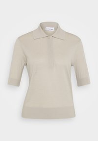 Beige Poloshirt mit kurzen Ärmeln, gerippten Bündchen und Saum, einer Knopfleiste und Calvin Klein-Label im Kragen.