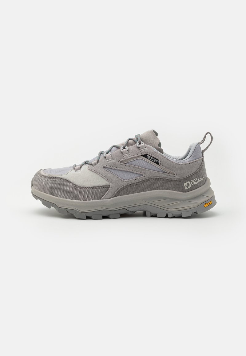 Zapato de senderismo gris que presenta una combinación de materiales de ante y malla, una suela de goma resistente y un diseño minimalista con acentos en azul claro.
