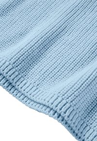 Vaaleansininen neulottu kangas, jossa on teksturoitu ribbimuotoilu näkyvillä langan yksityiskohdilla ja taittuneella reunalla. Pehmeä ja joustava materiaali.