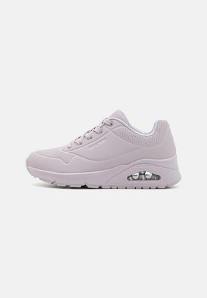 Scarpa sportiva di colore viola chiaro con superficie tessurizzata, punta rotonda, colletto imbottito e ammortizzazione ad aria visibile nella suola. Accenti perforati.