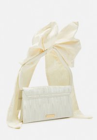 Ivory rectangular handbag with a textured pattern and large silky fabric bow handle tied at the top.