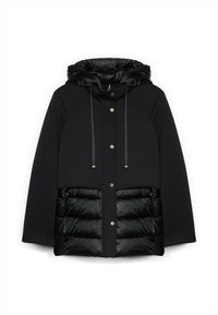 Musta takki, jossa on huppu, pehmeä kangas ylhäällä ja tikattu, pörröinen alaosa. Metalliset yksityiskohdat etupuolella.