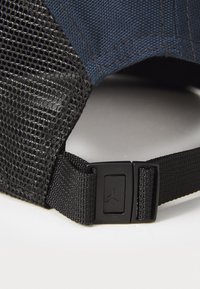 Sort mesh snapback hat med en blå stofkrone, der har en plastiklukning og et logopatch bagpå. Strukturerede og holdbare materialer.