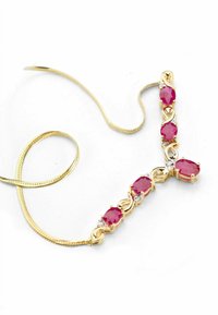 Zlatý náhrdelník s piatimi oválnymi ružovými drahokamami medzi malými čírymi kameňmi, spojený hladkými kovovými článkami a flexibilným reťazcom.