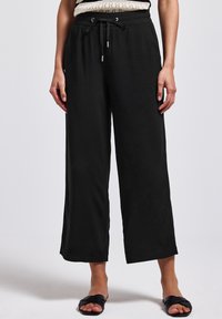 Pantalons larges noirs avec une taille élastique et un cordon de serrage réglable. Tissu lisse avec une coupe décontractée et sans motifs visibles.