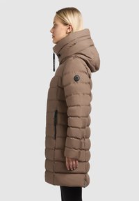Brown puffer coat featuring a high collar, zippered pockets, and a textured, quilted design. The fabric appears smooth and durable.