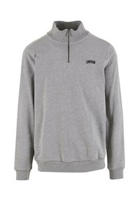 Harmaa vetoketjulla varustettu huppari, joka on valmistettu pehmeästä kankaasta. Siinä on korkea kaulus, ribbaus hihansuissa ja pieni "UNFAIR"-logo rinnassa.