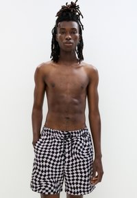 Czarno-różowe kąpielówki w kratkę z elastycznym pasem i sznurkiem, z falistym wzorem oraz kieszeniami bocznymi.